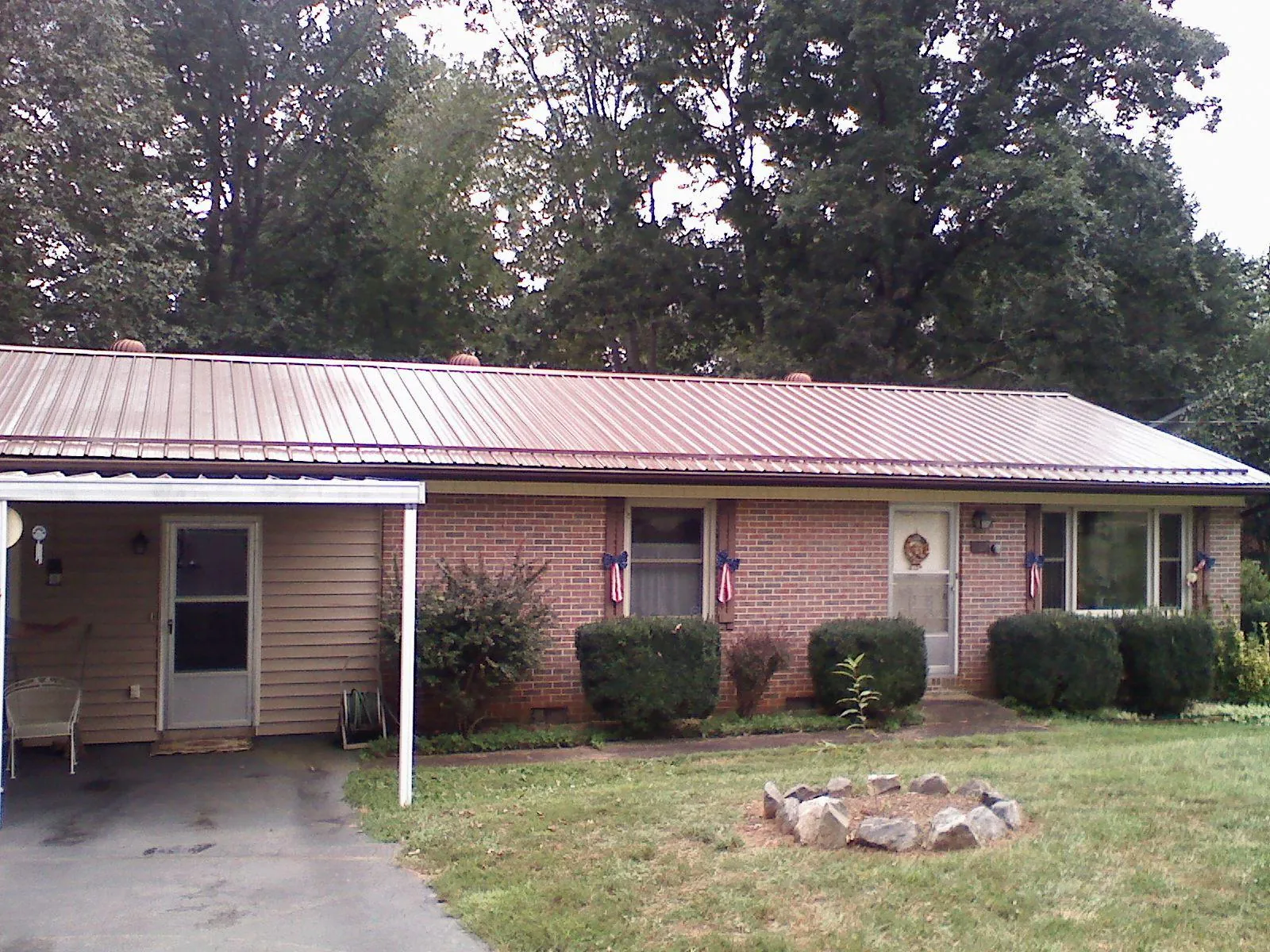 Bronze metal roof and carport on a brick ranch home — Roof Repair work by our crew in Malo