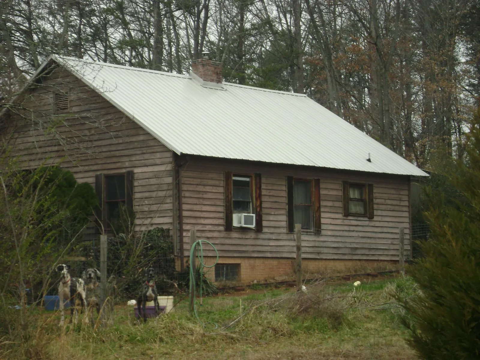 White metal roof on an old wood sided farmhouse, from a Metal Roof Installation job in Malo
